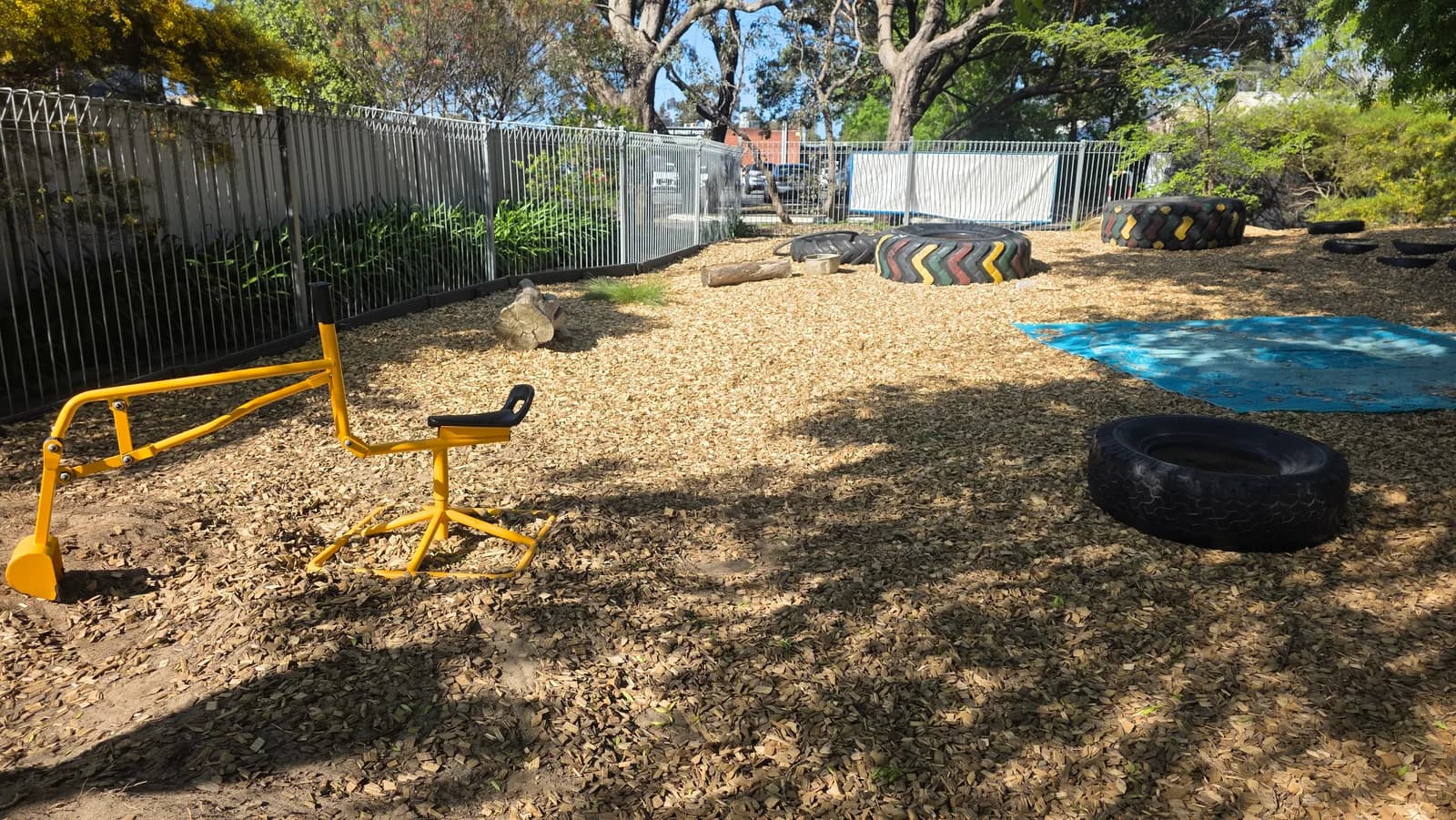 A yellow toy digger in the centre outdoor play area